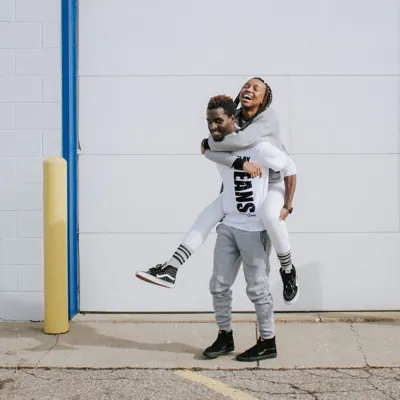 Woman getting a piggy back from her boyfriend as they share fun relationship questions