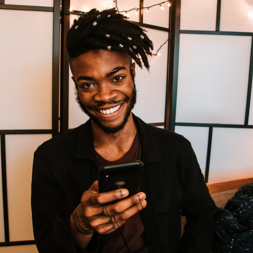 man smiling while sexting with his partner